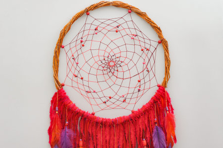 Closeup details modern dreamcatcher with painted colorful feathers on gray backgroundの写真素材