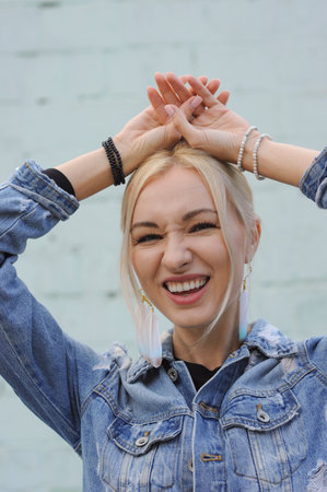 Close-up portrait of gorgeous blonde woman in boho chic feather earrings, bohemian jewelryの写真素材