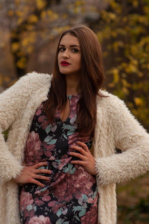 Glamor portrait of beautiful brunette lady with big eyes and red lips in park, Outdoors colorful autumnの写真素材
