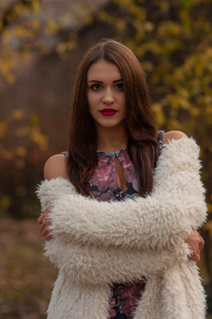 Glamor portrait of beautiful brunette lady with big eyes and red lips in park, Outdoors colorful autumnの写真素材