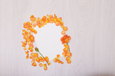 Creative mock up layout made of roses  with copy space on table homemade flat lay. Empty sheet of paper. Mockup with a card and orang roseの写真素材