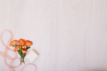 Creative mock up layout made of roses. Small bouquet of orange roses with copy space on table homemade flat layの写真素材