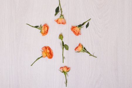 Creative mock up layout made of roses. Small bouquet of orange roses with copy space on table homemade flat layの写真素材