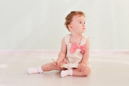 A little girl sitting in the studio and playing