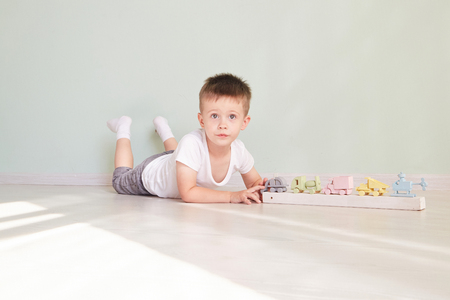 little boy plays with toy car at homeの写真素材