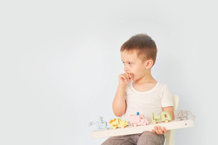 little boy plays with toy car at home