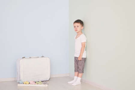 The boy in the bright white room with white suitcaseの写真素材