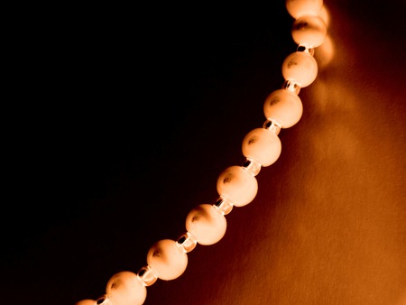 Part of a necklace from pearls on a dark background. Black and brown colors prevailの写真素材