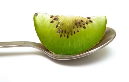Slice kiwi in a teaspoon. Isolation on white.の写真素材
