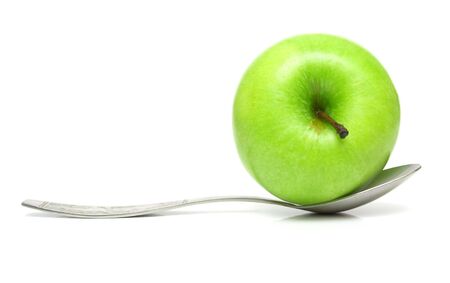Apple and spoon on the white. Isolation, closeup.の写真素材
