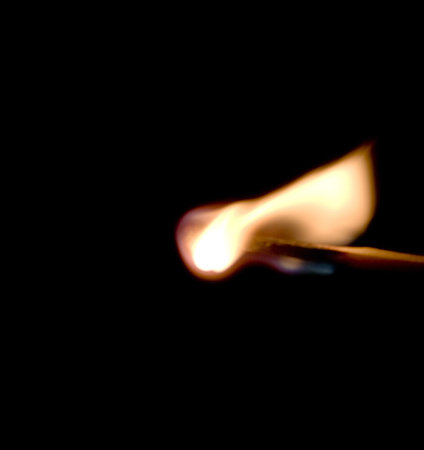 Burning match on a black background