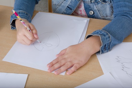 Hand of a child drawing on white paper, pencilの写真素材