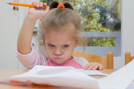 Little girl drawing at home with emotional facesの写真素材