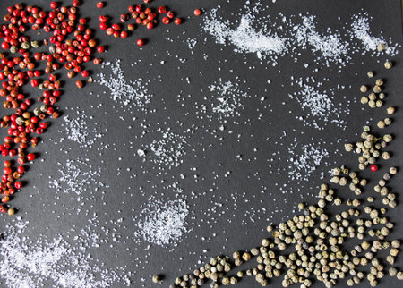 Sea salt and colorful peppercorns on a black background. Red and Green peppercorn.の写真素材