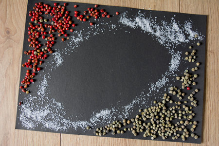 Sea salt and colorful peppercorns on a black background. Red and Green peppercorn.の写真素材