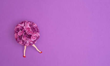 Bouquet of artificial two-tone purple roses with doll's legs on a purple background. Text space. Celebrations, weddings, Valentine's Day, concept. Minimal style. Top view. Flat lay.の写真素材
