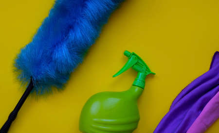 Duster and spray bottle on a yellow backgroundの写真素材