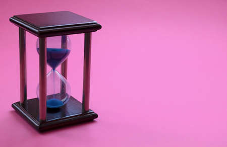 Hourglass on a pink backgroundの写真素材