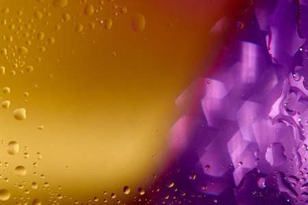 Metallic gold and glittering violet blurred background with water drops.の写真素材