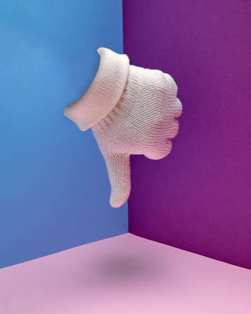 The hand in the white glove shows the thumb down. Hand gesture.の写真素材