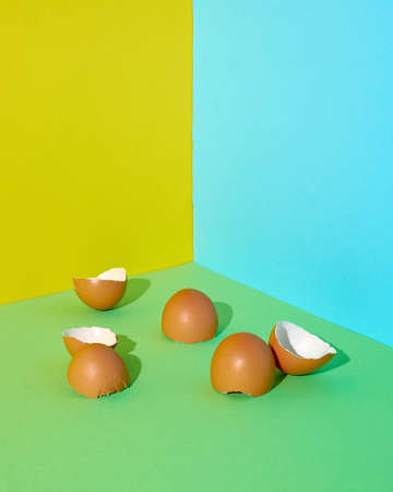 Egg shells on a green-yellow-blue background. Minimal style. Easter.の写真素材