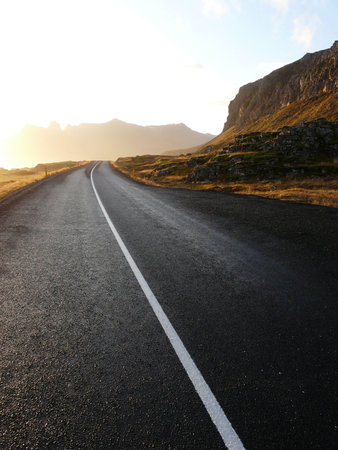 Wet road through the Eastfjords with the typical warm light in Iceland