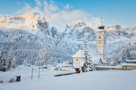 Church in front of Sella group Dolomites mountains in Colfosco, Italy. Beautiful winter landscape with snow.の写真素材