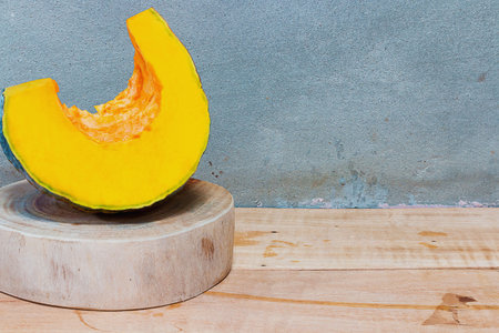 Pumpkins on Chopping Wood in the kitchen with concrete walls. The view from the side with copy...