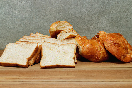 Croissant and Bread wheat on a wooden table in the kitchen. Breakfast concept.