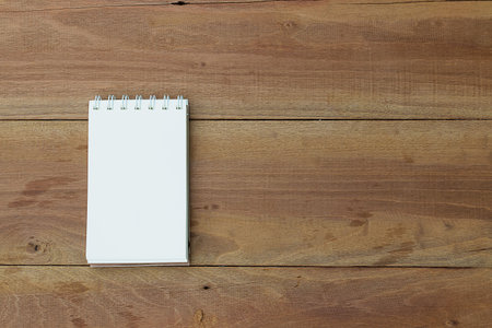 Notebook on office wooden table. Top view.