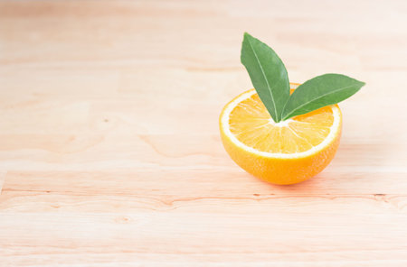 Orange half on wooden table, health concept.