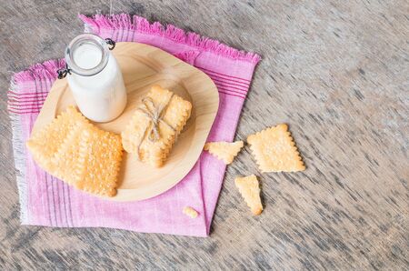 Bread and bottle of milk in wooden dish on wooden table for breakfast. Top view.の写真素材