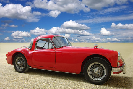 Classic red cabriolet on a background of the blue sky  