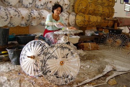 CHIANG MAI, THAILAND - JANUARY 1: Woman making a wooden umbrella in traditional umbrella factory on January 1, 2008 in Chiang Mai, Thailand のeditorial素材
