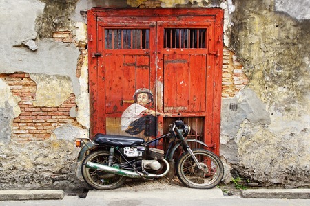 Georgetown, Malaysia - January 19, 2014  Graffiti  Boy on a Bike  by Lithuanian artist Ernest Zacharevic of a 2012 festival  Since then, many more wall paintings on the walls of old buildings  are one of the main tourist attractions のeditorial素材