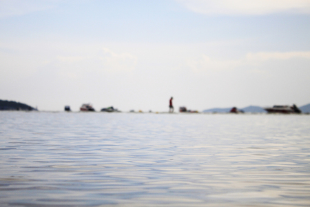 Sea waves close up in the evening and people playing sea backgroundの写真素材