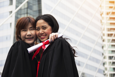 Beautiful girl students are happy after graduation.の写真素材