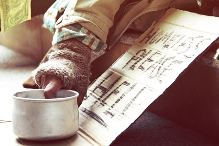 Could you please help homeless man sleeping on walkway street in the capticap city.の写真素材