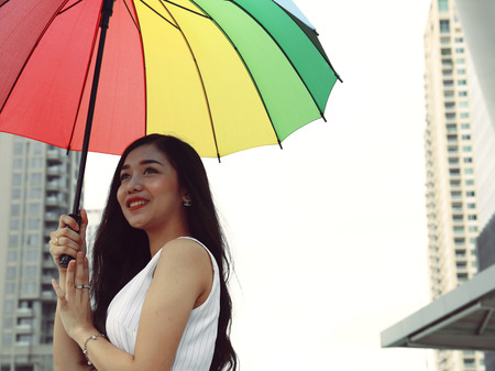 Beautiful women holding colorful umbrella in the street city.の写真素材