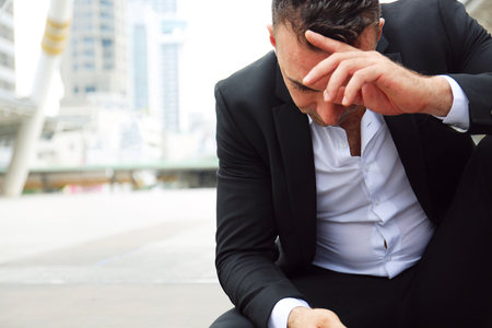 Businessman sitting sadness and thinking work on walking street.の写真素材
