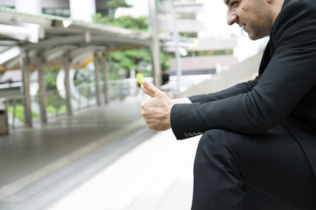 Beautiful business man sitting relaxation and thinking on street.の写真素材