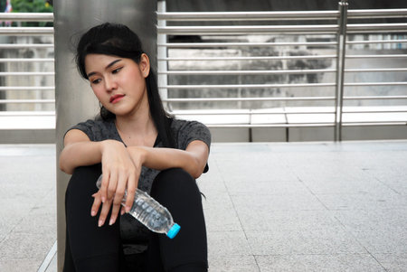 Beautiful sport women sitting sadness on walking street.の写真素材