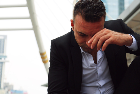 Businessman sitting sadness and thinking work on walking street.の写真素材