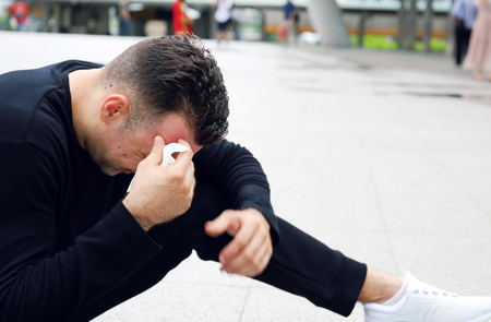 Sport man exercise Outdoor fitness hot and tired on walking street, Building office background.の写真素材