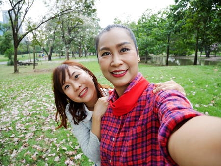 Close-up beautiful Mother and daughter are selfie photo relaxation time in the garden park.の写真素材
