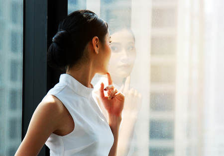 Beautiful Asia Business woman manager smile portrait and office building background in the capital city.の写真素材