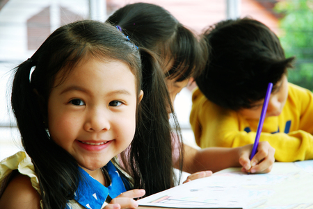 Kids boy and girls learning drawing on white paper in holiday weekend.の写真素材