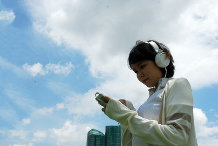 Beautiful women playing game application and listen sound on mobile phone.の写真素材