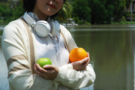 Beautiful women holding orange fruit and apple.の写真素材