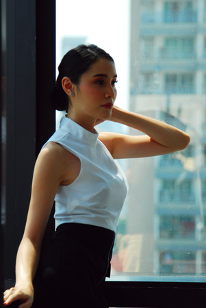 Beautiful Asia Business woman manager smile portrait and office building background in the capital city.の写真素材